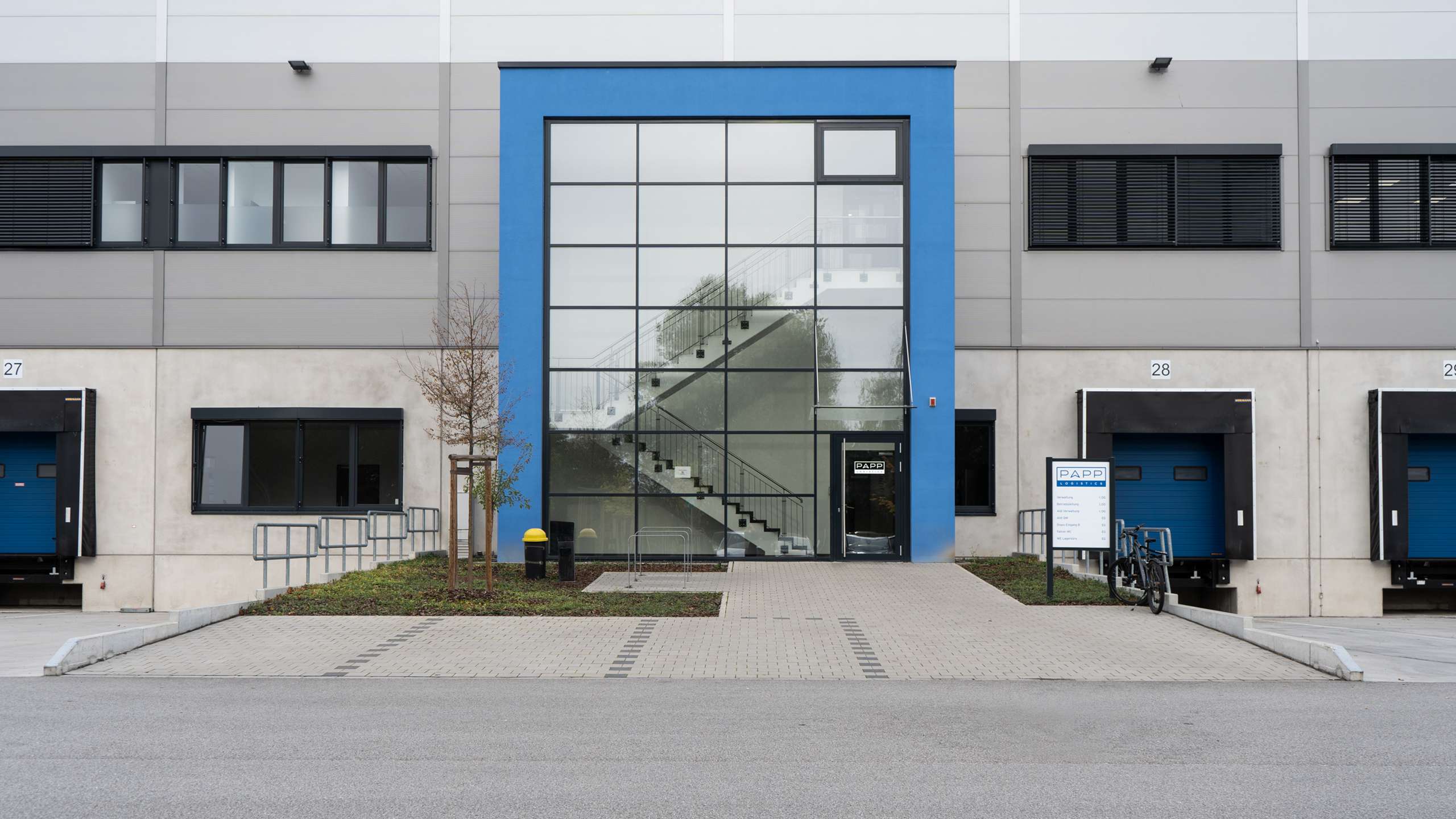 Ein Blick auf das Gebäude von PAPP Logistics in Ginsheim-Gustavsburg. Das Treppenhaus befindet sich hinter der Fensterfront des blauen Gebäudeteils.